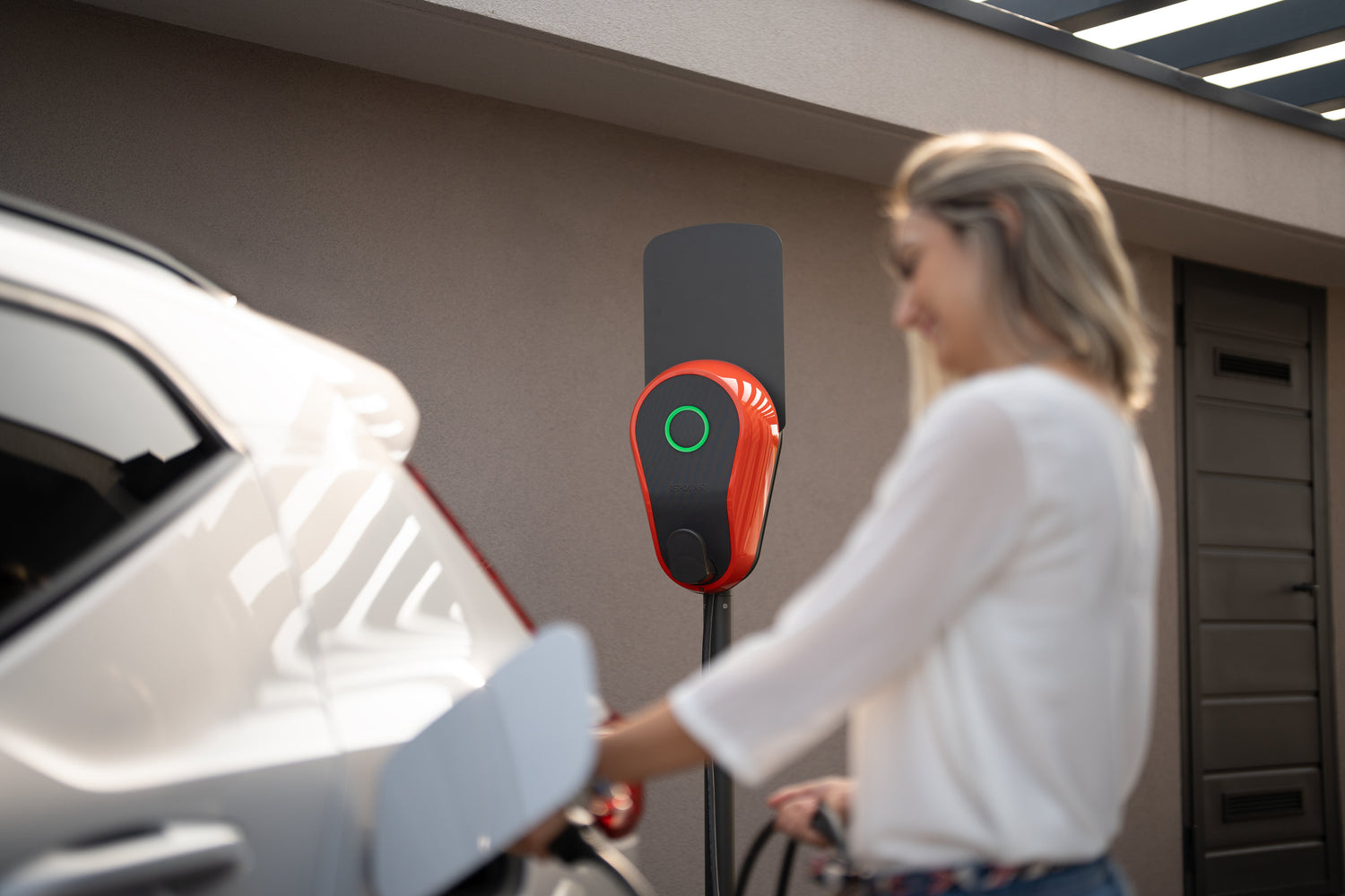 Donna che ricarica la sua auto elettrica con colonnina di ricarica Giotto Repower